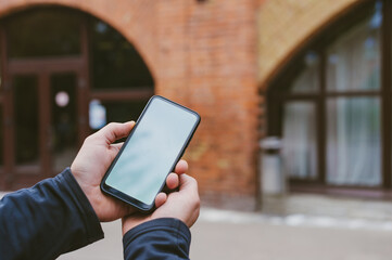 Mock-up technology. Man holds a smartphone in his hands close-up.