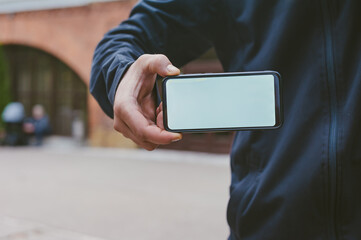 Mock-up technology. Man holds a smartphone in his hands close-up.