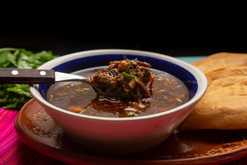 Mexican birria consome soup and tacos on turquoise background