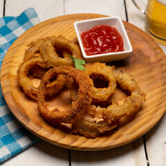 Onion rings with ketchup on white background