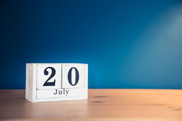 July 20 - white calendar blocks on wooden table against vintage blue background