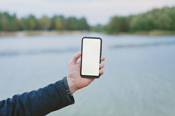Mock-up technology. Man holds a smartphone in his hands close-up.
