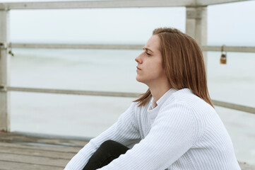 Young girl photographed on the beach on a rainy autumn day