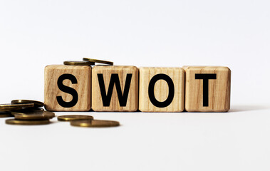 wooden cubes and SWOT, coins, the concept of taxation, increase taxes and fees