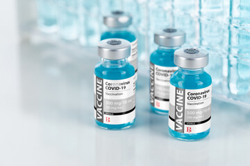 Coronavirus COVID-19 Vaccine Vials Near Test Tubes On Reflective Surface