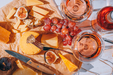 set of different types of cheese. romantic dinner for two. cheese fruit and two glasses of wine