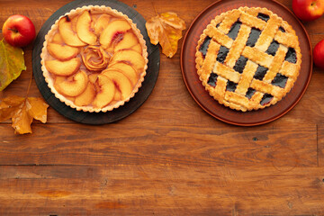 Thanksgiving berry and apple various pies on wooden surface, top view