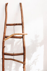 Vintage wooden staircase with hangers on white wall background in minimalist home interior style
