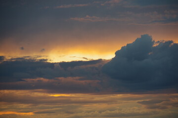 Dark storm clouds with colorful reflections of the setting sun.  Scenic storm clouds lit by the last rays of the sunset.