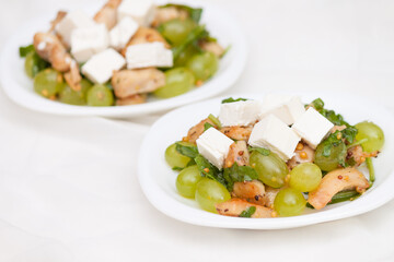 Tasty and healthy salad with feta cheese, grapes, chicken, arugula.