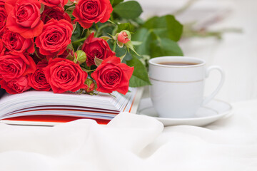An open book with red orange roses. Reading and relaxing. Romantic, sweet, dating concept.