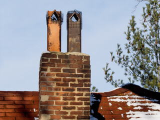 two very old fireplace chimneys with spark preventer mesh in the clay flues