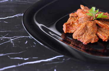 Lamb slow stewed with vegetables in a bowl close-up on dark marble background. meat dish