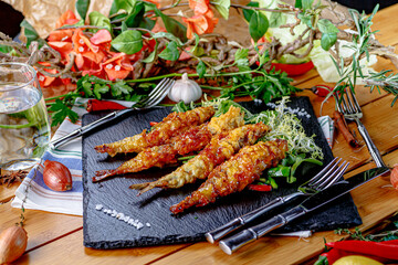 Deep-fried langoustines in batter lie on a plate in a restaurant.