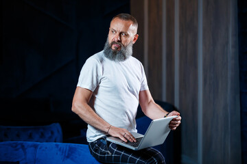 Adult male businessman, teacher, mentor working on a new project. Sits by a large window on the...