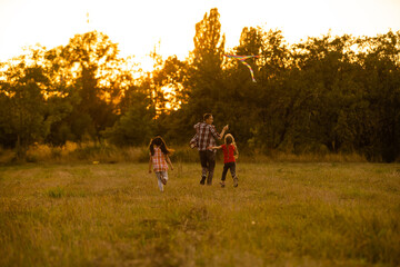 Fototapeta premium happy family father and child daughter run with a kite on meadow