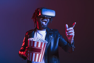 Man with VR glasses and popcorn watches a 3D film