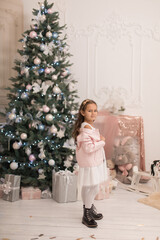 Beautiful little girl posing near the Christmas tree