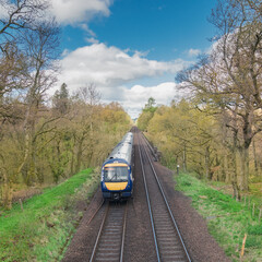 Train and railway tracks in a rural scene with nice pastel blue sky - Scotland