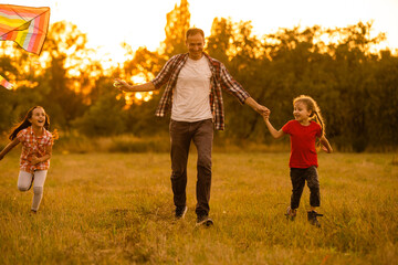 Fototapeta premium Dad with his little daughter let a kite in a field