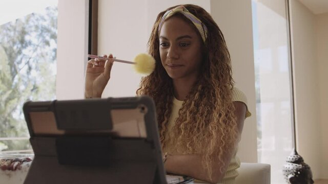 Woman Studying and Listening Carefully During Online Class iPad in Front of Her
