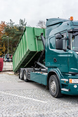 Truck loading container with waste in recycling center