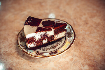 close up of a chocolate cream cake on golden plate