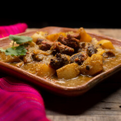 Mexican longaniza with green sauce and potatoes on wooden background