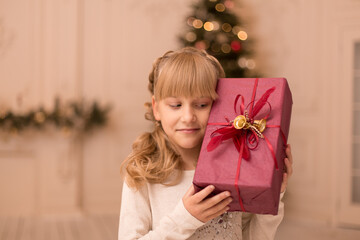 A little girl in the morning found a Christmas present from Santa under the tree