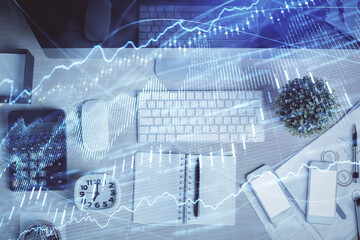 Double exposure of forex graph drawing over desktop background with computer. Concept of financial analysis. Top view.