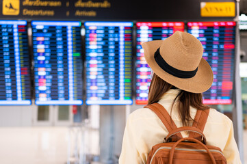 New normal travel domestic flight Asian woman wearing face mask searching flight on timetable in...