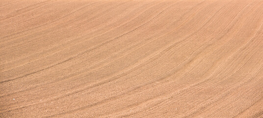 Rows of soil before planting.Furrows row pattern in a plowed field prepared for planting crops in...