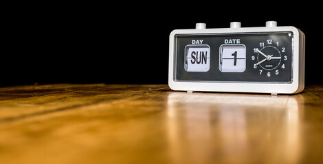 First day of the month, first Sunday of the month - vintage alarm clock with date on a wooden table - copy space