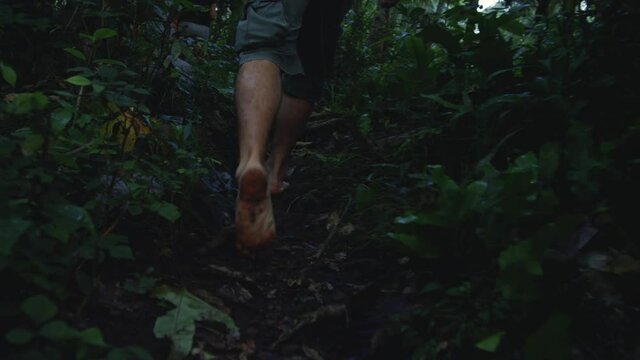 Bare feet walking along jungle path in Bali