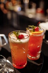 Summer cranberry lemonade garnished with mint and cherries on the bar