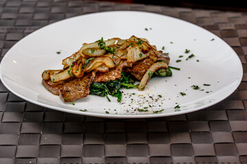 Roast beef liver with spinach and onions on a plate