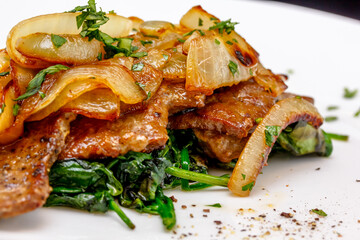 Roast beef liver with spinach and onions on a plate