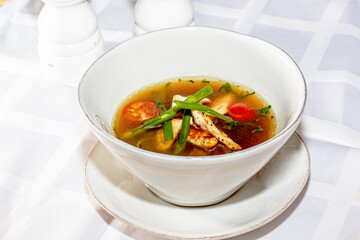 Concasse soup with chicken, tomatoes and green onions is on the plate
