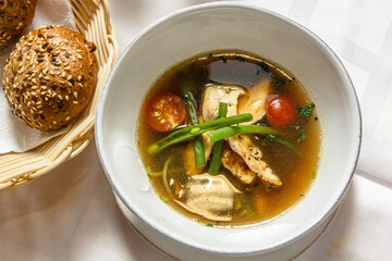 Concasse soup with chicken, tomatoes and green onions is on the plate