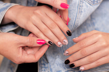 Obraz na płótnie Canvas Manicurist holding female hands with fashion manicure nails, stylish design, nude and black gel polish for photoshoot