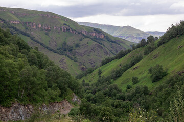 Naklejka premium Mountain landscape with blue sky. Panoramic view of green hills.