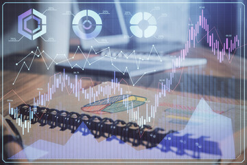 Double exposure of financial graph drawings and desk with open notebook background. Concept of forex market