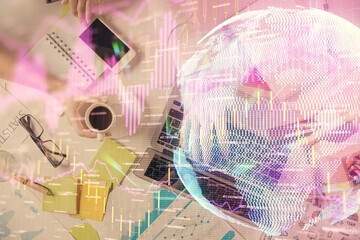 Multi exposure of man's hands typing over computer keyboard and forex graph hologram drawing. Top...
