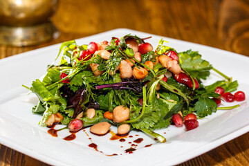 Salad with boiled beans, coriander and other herbs is on the plate