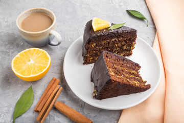 Homemade chocolate cake with orange and cinnamon with cup of coffee on a gray concrete background. side view.