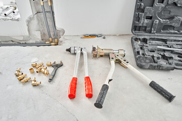 Tools for Work As A Plumber. Connection heating pipes to white Radiator in a new apartment under construction. water heating radiator on the white wall indoors