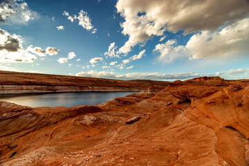 The sun hiding behind the clouds and increasing the contrast of the Colorado basin scenery, The Chains, Page, Arizona, USA