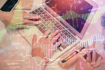 Multi exposure of woman hands typing on computer and forex chart hologram drawing. Stock market...