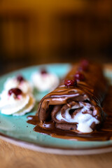 chocolate pancake with bananas, nuts and chocolate sauce. the toning. selective focus. 
a rolled chocolate pancake is a calorie bomb