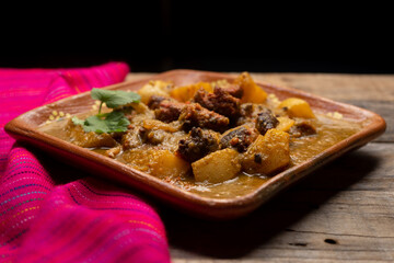 Mexican longaniza with green sauce and potatoes on wooden background